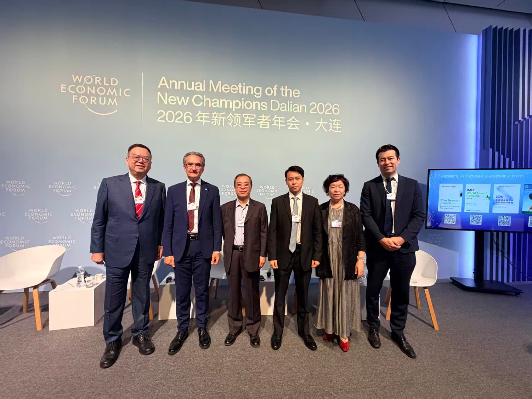 Qiqing He standing with expert panelists at the Annual Meeting of the New Champions 2026 in Dalian