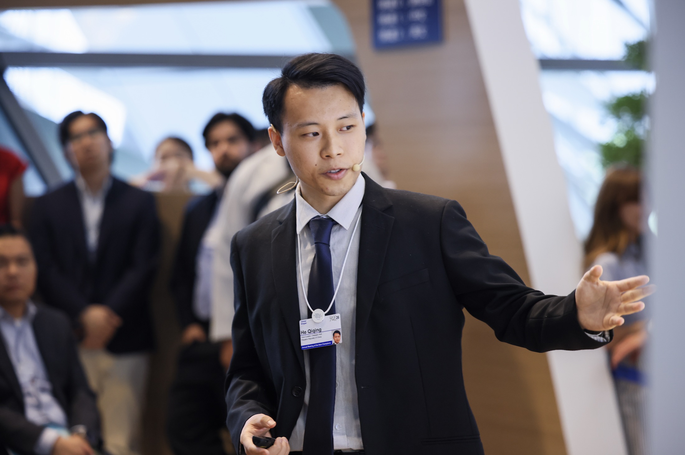 Qiqing He speaking with a headset microphone during the Hub Session
